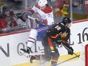 Montreal Canadiens' Arber Xhekaj, left, collides with Calgary Flames' Andrew Mangiapane behind the net during first period in Calgary on Dec. 1, 2022.