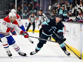 Seattle Kraken left wing Jared McCann (19) advances the puck while being defended by Montreal Canadiens right wing Evgenii Dadonov (63) during the first period at Climate Pledge Arena in Seattle on Dec. 6, 2022.