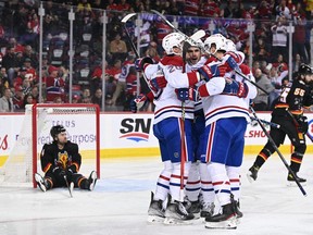 Canadiens forward Juraj Slafkovsky (20) celebrates his goal with teammates on Calgary Flames defenceman Rasmus Andersson (4) during the first period at Scotiabank Saddledome in Calgary, on Dec. 1, 2022.