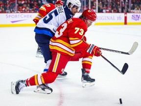 L'ailier droit des Flames de Calgary Tyler Toffoli et les Jets de Winnipeg Mark Chifley jouent le rôle de jockey pour la rondelle lors de la troisième période au Scotiabank Saddledome de Calgary le 12 novembre 2022.