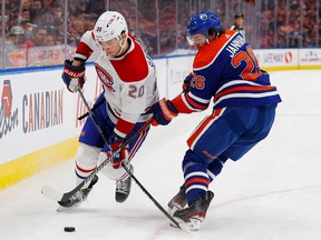 Canadiens forward Juraj Slafkovsky (20) and Edmonton Oilers forward Mattias Janmark (26) battle along the boards for a loose puck during the second period at Rogers Place in Edmonton on Saturday, Dec. 3, 2022.