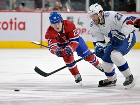 Tampa Bay Lightning forward Brayden Point plays the puck against Canadiens' Cole Caufield during the third period at the Bell Centre in Montreal on Saturday, Dec. 17, 2022.