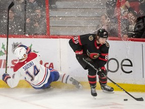 Canadiens centre Nick Suzuki (14) hits the boards after chasing Ottawa Senators defenceman Jake Sanderson (85) in the third period at the Canadian Tire Centre in Ottawa on Dec. 14, 2022.