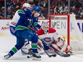 Canadiens goalie Sam Montembeault (35) looks on as forward Christian Dvorak (28) battles for the rebound with Vancouver Canucks forward Nils Hoglander (21) in the first period at Rogers Arena in Vancouver on Dec. 5, 2022.