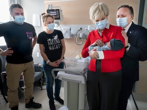 Quebec Premier François Legault looks on as his wife Isabelle Brais, right, holds eight-day-old premature baby Youri as parents Justine Pepin-Blais and Alexandre Gervais look on at Ste-Justine Hospital in Montreal, Thursday, Dec. 22, 2022.