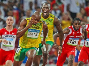 Jamaica's Usain Bolt yells encouragement at teammate Asafa Powell as Powell takes the baton for the anchor leg of the men's 4 X 100-metre relay at the National Stadium at the Olympic Games in Beijing August 22, 2008.