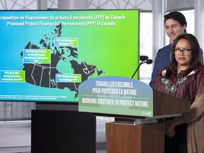 Grand Chief Alison Linklater delivers remarks as Prime Minister Justin Trudeau looks on during a news conference in Montreal on Wednesday, December 7, 2022.