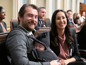 Quebec Liberal MNA Gregory Kelley holds his son Gabriel as mother Marwah Rizqy, also an MNA smiles, Tuesday, Dec. 6, 2022 at the legislature in Quebec City. The couple brought their newborn son to question period.