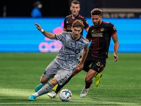 CF Montréal midfielder Matko Miljevic (11) controls the ball in front of Atlanta United defender George Campbell (32) during the second half at Mercedes-Benz Stadium on March 19, 2022.