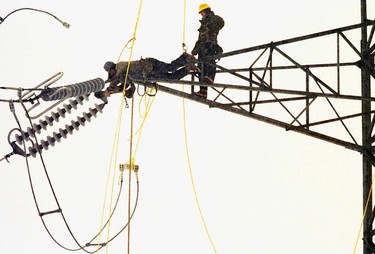 Two Hydro-Québec workers perch precariously atop a hydro tower in St-Césaire on Jan. 22, 1998.