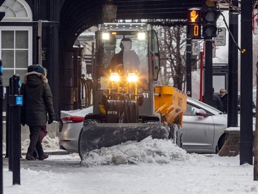 A tractor plows and sands the sidewalk on Sherbrooke Street after Montreal was hit with a combination of ice pellets, snow and freezing rain overnight Thursday Jan. 5, 2023.
