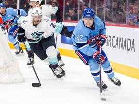 Canadiens' Cole Caufield is pursued by the Seattle Kraken's Carson Soucy during the first period of a National Hockey League game in Montreal Monday Jan. 9, 2023.