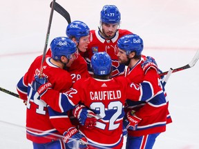 Canadiens' Cole Caufield is congratulated by teammates, from left, Nick Suzuki, Christian Dvorak, Kirby Dach and Jonathan Drouin after scoring his second goal of the game during third period of a National Hockey League game against the Nashville Predators in Montreal Thursday Jan. 12, 2023.