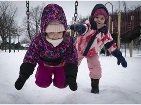 All bundled are four year-old Klara Gavrilovic who gives a push to her two year old cousin Petra Stojanovic on the swings at Centennial park in Dollard-des-Ormeaux on Sunday.
