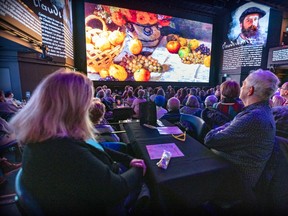 Patrons sit at tables as they watch the 2D portion of the new exhibition Lasting Impressions at Le Studio-Cabaret/Espace St-Denis in Montreal on Wednesday, Jan. 11, 2023. The second half of the show is presented in 3D.