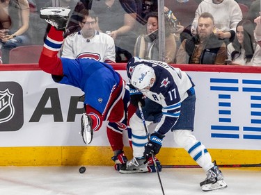 Montreal Canadiens centre Christian Dvorak (28) is upended along the boards next to Winnipeg Jets centre Adam Lowry (17) during 1st period NHL action at the Bell Centre in Montreal on Tuesday Jan. 17, 2023.