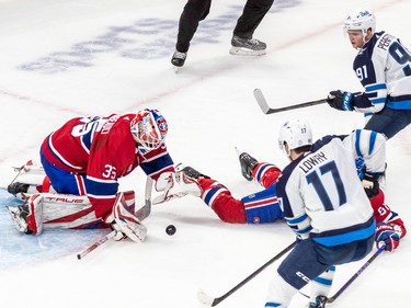 Montreal Canadiens goaltender Sam Montembeault (35) grabs the loose puck with Winnipeg Jets centre Adam Lowry (17) and Jets centre Cole Perfetti (91) on the doorstep during 2nd period NHL action at the Bell Centre in Montreal on Tuesday Jan. 17, 2023.