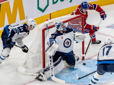 Montreal Canadiens centre Kirby Dach (77) attempts a wrap-around goal against Winnipeg Jets goaltender Connor Hellebuyck (37) during 3rd period NHL action at the Bell Centre in Montreal on Tuesday January 17, 2023. Mike Hoffman tapped the rebound in to give Montreal a 4-1 lead.