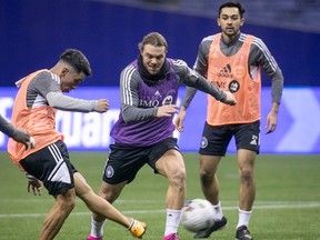CF Montreal player Joaquin Torres, left, with Samuel Piette, centre, and Mathieu Choiniere during practice at the Olympic Stadium on Wednesday January 18, 2023.