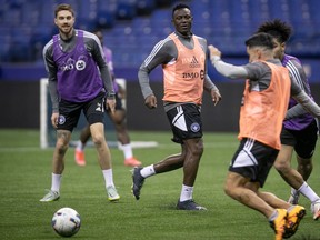 CF Montréal midfielder Victor Wanyama, centre, and Joel Waterman, left, during practice at the Olympic Stadium on Jan. 18, 2023.