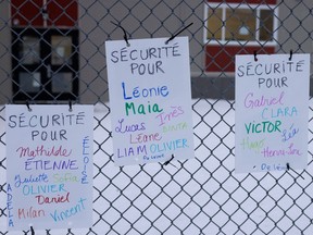 Signs calling for increased pedestrian safety line the fence outside École Fernand Séguin in Montreal on Jan. 24, 2023.
