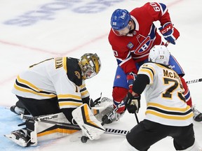 Boston Bruins goaltender Jeremy Swayman stops Montreal Canadiens' Alex Belzile as Charlie McAvoy defends during third period in Montreal on Jan. 24, 2023.