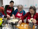 Lac St Louis Corbeille de Pain kitchen animator Rania Abunowara, left, helps out Maria Pagliuca, centre, and Irene Fahy prepare stuffed pasta filling during a community kitchen held in Pointe-Claire.