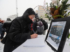 Pierre Lachapelle of Trajectoire Québec signs a book of condolence at a memorial service for the 10 Minute Max network near the Place des Arts métro station.