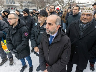 Samer Majzoub, centre, of the Forum Musulman Canadien listens to proceedings during a ceremony to remember the people slain in the 2017 Quebec City mosque shooting in Verdun on Friday, Jan. 27, 2023. Next to him, with black cap, is Mohamad Jundi, from the same organization.