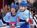 Canadiens' captain Nick Suzuki and Rafaël Harvey-Pinard celebrate after Harvey-Pinard tied the game 3-3 in the third period Tuesday night at the Bell Centre.