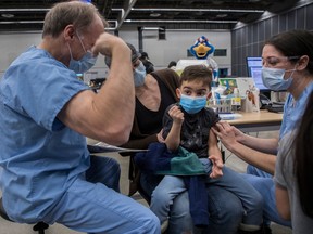 Marcus Gabriel makes a muscle as he gets a vaccine to protect against COVID-19 at the Palais des congrès last February.