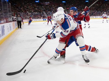 Canadiens defenceman Johnathan Kovacevic (26) gets knocked off the play by New York Rangers left wing Jimmy Vesey (26) during NHL action in Montreal, on Thursday, Jan. 5, 2023.