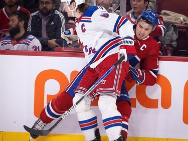Canadiens centre Nick Suzuki (14) grimaces as he is hit by New York Rangers defenceman Jacob Trouba (8) during NHL action in Montreal, on Thursday, January 5, 2023.