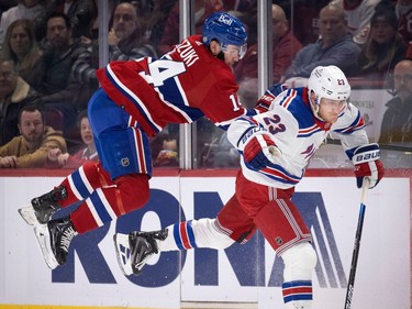 Canadiens centre Nick Suzuki (14) gets airborne as he tries to avoid a collision with New York Rangers defenceman Adam Fox (23) during NHL action in Montreal, on Thursday, Jan. 5, 2023.