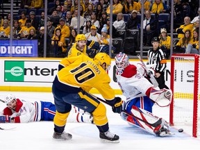 Colton Sissons #10 of the Nashville Predators scores off a crossing pass from Filip Forsberg #9 as Joel Edmundson #44 and Sam Montembeault #35 of the Montreal Canadiens defend during the first period at Bridgestone Arena on January 3, 2023 in Nashville, Tennessee.