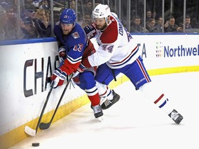 Canadiens' Joel Edmundson (44) checks Alexis Lafreniere (13) of the New York Rangers into the boards during the second period at Madison Square Garden on Sunday, Jan. 15, 2023, in New York City.