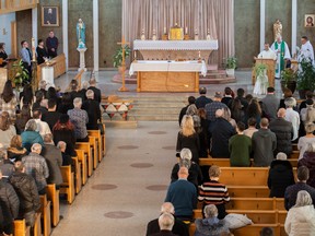 People attend a mass in St-Roch-de-l'Achigan, Que., Sunday, January 15, 2023, in memory of the victims of a propane explosion the previous Thursday.