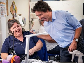 Prime Minister Justin Trudeau shares a laugh with a worker during his visit to a Flo Electric production facility in Shawinigan on Jan. 18, 2023.