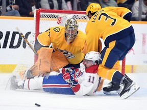 Montreal Canadiens right wing Brendan Gallagher (11) is taken to the ice by Nashville Predators defenceman Jeremy Lauzon (3) as he tried to shoot against goaltender Juuse Saros (74) during the first period at Bridgestone Arena in Nashville on Jan. 3, 2023.