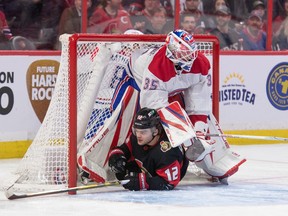 Senators' Alex DeBrincat (12) slides into Canadiens goalie Sam Montembeault in the first period at the Canadian Tire Centre in Ottawa on Saturday, Jan. 28, 2023.