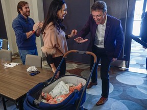 Interim leader of the Quebec Liberal Party Marc Tanguay, right, greets MNAs Marwah Rizqy and Gregory Kelley, left, and their baby as he arrives to a caucus meeting in Lac-Beauport, north of Quebec city, Tuesday, Jan. 24, 2023.