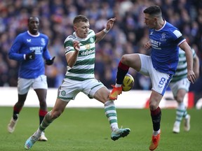 Celtic's Alistair Johnston, left, and Rangers' Ryan Jack battle for the ball during the Scottish Premiership League soccer match at Ibrox Stadium, Glasgow, Monday Jan. 2, 2023.