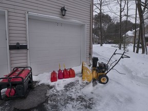 A generator and gas cans sit outside a home in St-Lazare, west of Montreal, on Dec. 24, 2022. Hydro-Québec says almost all of its customers who lost power in a Dec. 23 winter storm have now been reconnected.