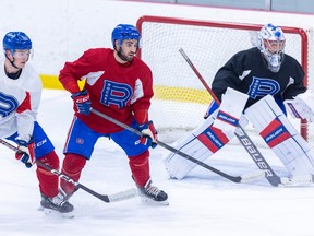 Peter Abbandonato sets up between defenceman Mattia Norlinder and goalie Cayden Primeau during Laval Rocket practice at the Place Bell Sports Complex in Laval on Jan. 31, 2023.