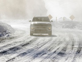 A car drives through blowing snow on Ile Ste-Hélène on a bitterly cold and windy day in February.