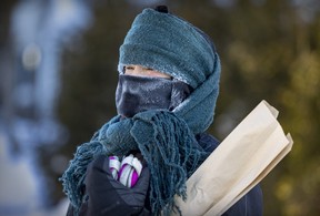 Pascale Payant wrapped her hood with a scarf over a neck warmer for a frosty walk home from the store on a bitterly cold and windy day in the Lachine borough of Montreal on Friday, Feb. 3, 2023.