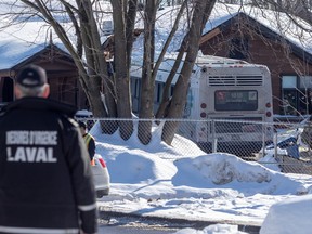 a laval bus at the scene of a daycare crash in laval with a police officer in the foreground