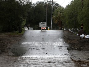 Floodwaters flow over a road in Santa Clarita, Calif., in this file photo.