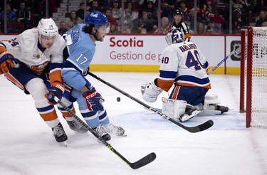 New York Islanders defenceman Scott Mayfield (24) ties up Montreal Canadiens right wing Josh Anderson (17) as New York Islanders goaltender Semyon Varlamov (40) allows a rebound during first-period action in Montreal on Saturday, Feb. 11, 2023.
