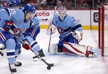 Montreal Canadiens goaltender Sam Montembeault (35) looks on as Montreal Canadiens left wing Rafael Harvey-Pinard (49) carries the puck away from Montembault's crease during 2nd-period action against the New York Islanders in Montreal, on Saturday, Feb. 11, 2023.